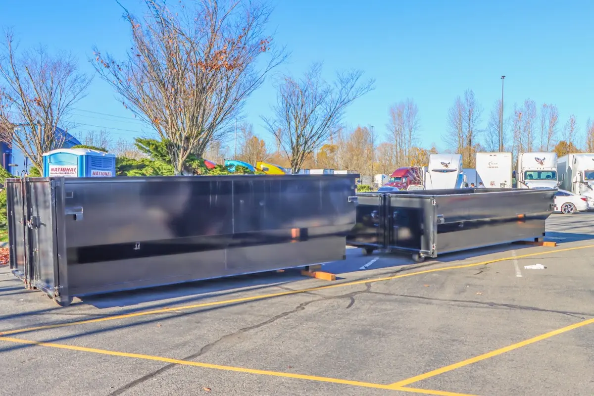 Professional dumpster rental service with roll-off container on residential driveway in Naranja